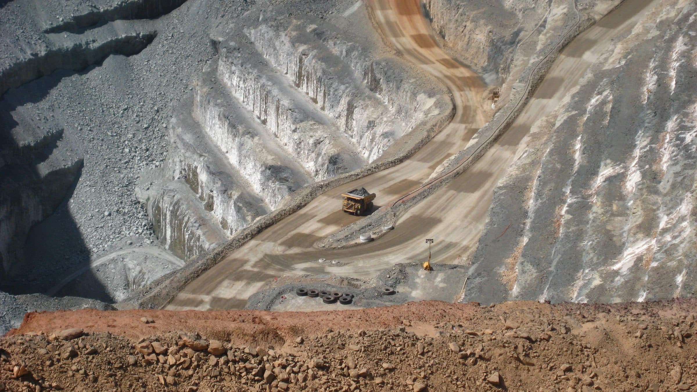 Access ramp of an open-pit mine seen from above, with a haul truck climbing