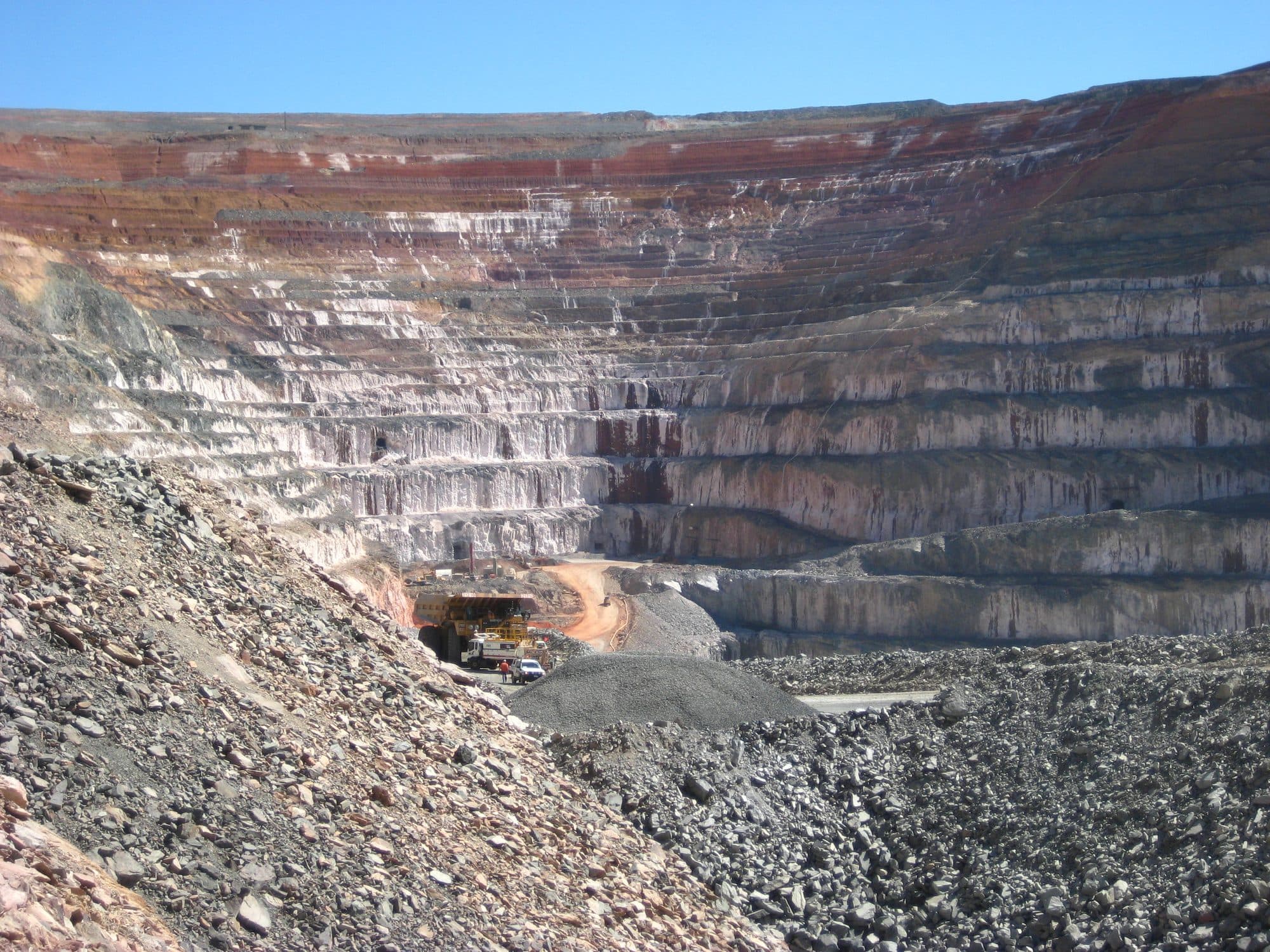 Benches of an open-pit mine under a blue sky